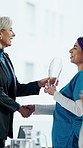 Handshake, medal and manager with nurse in board meeting, onboarding or partnership in healthcare. Trophy, professional and CEO shaking hands with medical worker for service thank you in clinic.