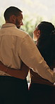 Love, couple and hug with window view in home, connection and bonding together for support. Back, man and woman embrace partner at house for loyalty, security and safety with healthy relationship