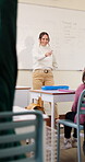 Answer, teaching and children in classroom at school for learning, test or quiz by teacher. Smart, raised hands and students with woman by whiteboard for education question, knowledge or solution