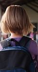 Walking, student or girl with backpack in school for curriculum, academic development or lesson journey. Education, back or child with bag for learning, knowledge growth or academy hallway for future