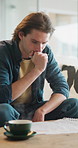 Man, document and stress on sofa for debt, eviction letter or financial decision at home. Worried, planning and person with anxiety and paperwork of budget, mortgage or loan for bankruptcy risk