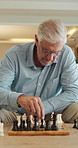 Senior man, chess and game in home with strategy, solution or problem solving in contest in living room. Old person, boardgame and idea with competition for thinking, knowledge or challenge on sofa
