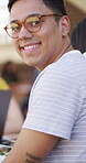 Education, face and happy man with glasses in library, laughing or study with textbook for knowledge. University student, portrait and person with smile for academic growth, scholarship and learning