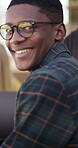 Library, face and man with smile for education, glasses and study with textbook for academic growth. University student, portrait and exam preparation with friends, laugh and person with scholarship