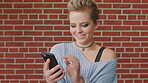 Phone, smile and woman in college for online, internet or communication with funny chat at wall. Laugh, happiness and student for social media, learning and break with streaming service or campus app