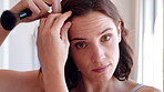 Woman, face and hair with makeup brush in home for beauty cosmetics, haircare or foundation. Portrait, female person or POV with aesthetic tool or hairstyle for cosmetology or makeover in house