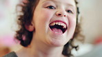 Laughing, childhood and face of girl in home for positivity, funny joke and relax on weekend. House, bedroom and portrait of child with smile, good mood and humor for development, growth and break