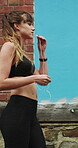 Runner, earphones and health with woman in city for streaming service, fitness podcast and cardio. Wellness, exercise playlist and training music with person outdoor for audio, workout and radio