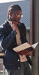 College, student and man with book, outdoor and exam preparation with info and academic development. Learner, reading and person with textbook for research, learning and scholarship opportunity