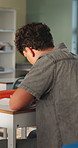 Student, college and boy in classroom for writing notes, studying and learning in lesson. School, academy and person with notebook for education, knowledge and  prepare for exams at university