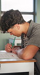 Education, college and boy in classroom for writing notes, studying and learning in lesson. School, students and person with exam for assessment, knowledge and answer for assignment at university