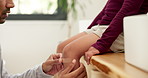 Hands, child and dad with plaster on knee in home with help, support and injury with legs for accident. People, father and kid with bandage, emergency or cover wound with first aid in family house