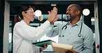 Happy, doctor and high five with tablet for medical discussion, winning or teamwork in hospital. Man, woman or healthcare workers with smile, technology or success for achievement together in hallway