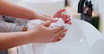 Bathroom, washing hands and parent with towel for child for hygiene, drying and cleaning in home. Family, learning and person with kid with fabric for wellness, health and help for development