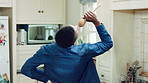 Singing, cooking and black man with spoon in kitchen for lunch, meal prep and ingredients. Home, happy and person with audio, playlist and song for groove, rhythm and karaoke with recipe on weekend