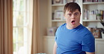 Face, funny and man with smile in home for playful expression, fun personality and goofy. Happy, person with down syndrome and silly humor in house for weekend break, positive attitude and cheerful