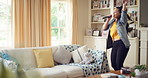 Singing, dancing and happy woman with remote in home for good mood, positive energy and karaoke. Weekend, living room and person with lyrics for music, audio and playlist for groove, moving and fun