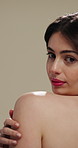 Woman, skincare and shoulder with hygiene, cosmetics or beauty treatment on a studio background. Female person, relax and gentle touch with smile or makeup for dermatology, shine or skin texture