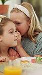 Food, whisper and children at lunch in home with gossip, conversation or bonding together. Talking, health and girl kids at meal in dining room for confidential information, private story or secret.