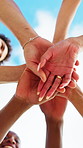People, huddle and hands together with team in nature for community mission or collaboration below. Low angle, group or friends piling with stack under blue sky for outdoor support, unity or trust