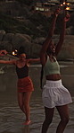 Sparklers, happy and group of friends by beach for summer vacation, getaway or weekend trip together. Fireworks, travel and people by ocean for adventure on seaside holiday with social gathering.