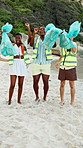 Face, winning or happy people with bag for recycling, cleaning or pollution on sandy shore together. Portrait, group or volunteer with smile or garbage for community service, success or earth day