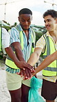 People, volunteer and hands together on beach for recycling, earth day or mission in nature. Happy team, group or friends piling with stack or smile for cleaning, dirt removal or community service