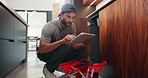 Sink, repair and man with tablet in kitchen, typing or damage inspection of drainage system in house. Handyman, online and pipe improvement with tools, scroll and quality assurance with tech in home