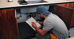 Plumber, writing and man with clipboard in kitchen, check leak and damage inspection of water system. Handyman, home repair and pipe improvement with info, notes and quality assurance with checklist
