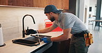 Check, faucet and man in kitchen, plumbing and fixing sink with tools and water inspection in house. Happy, plumber and maintenance with equipment, quality assurance and leak prevention in home