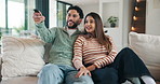 Love, happy and couple watching tv on sofa with remote control for film, movie or excited in home. Relax, television and people in lounge with laugh, comedy and entertainment for weekend or holiday
