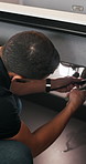 Man, plumber and fixing sink with wrench for pipe leak, repair service or installation in home. Male person, handyman or tinker with basin adjustment for water flow or plumbing maintenance in house