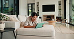 Woman, laughing and chill with tablet in home, scroll or reading ebook and thinking with non fiction. Browse, novel and mature person with tech for entertainment, remember or relax with smile on sofa