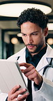 Tablet, man and doctor with reading for healthcare, thinking and review report in hallway. Reflection, physician or medical professional with tech for telehealth, management and support in hospital