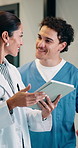 Medical, tablet and doctor with nurse for help, advice or planning schedule on digital app. Telehealth, team and happy woman with residency student for healthcare, discussion or support with question
