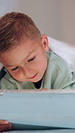 Boy, tablet and smile with typing in bed with games, digital puzzle and relax with comfort at home. Child, happy and tech with application, streaming or subscription for video on web at apartment