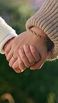 Person, park and holding hands with kid for bonding, support and adventure outdoor. Family, garden and parent with love and safety for child with development, connection and trust in nature together