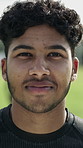 Face, athlete and man on soccer field for exercise, training and match practice for tournament. Portrait, smile and fitness with male person for football, sports contest and confident for competition