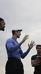 Rugby, team and discussion outdoor with coach, explain strategy or advice for tournament practice. Low angle, sports manager and people with game plan, tactical conversation or instructions for match
