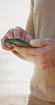 Phone, scrolling and hands of man by beach for texting, chatting or social media on holiday. Technology, typing and male person with cellphone for email on mobile app by ocean for vacation or weekend