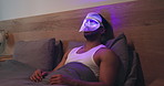 Blue light, mask and man with cosmetics for skincare, relax or wellness with antibacterial facial. Health, beauty tech and male person on bed with LED phototherapy for dermatology treatment in home