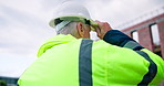 Back, man and engineer at construction site with hard hat, safety and inspection for architecture. Mature person, helmet and contractor outdoor with ppe, quality assurance and building development