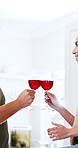 Hands, couple and cheers with red wine in kitchen for anniversary, marriage celebration or kiss. Flare, happy people and alcohol toast in home for relationship growth, bonding together and connection