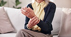 Home, hands and senior woman with wrist pain for arthritis, nerve compression and inflammation. Retirement, elderly person and muscle massage on sofa with discomfort, rheumatism risk and osteoporosis