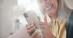 Phone, chat and senior woman in lounge, laughing and communication with contact on social media app. Texting, flare and elderly person with mobile, connection and reading funny message in house