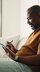 Tablet, pen and black man on sofa in home for remote work with web development for online research. Digital technology, stylus and mature programmer with software update, system or app project.