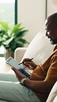 Tablet, relax and black man on sofa in home for remote work with web development for online research. Digital technology, stylus and mature programmer with software update, system or app project.