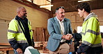 Architecture, deal or men in workshop with handshake, meeting or negotiation success for furniture vendor. Team, client or contractor with shaking hands, partnership or supplier agreement in woodwork