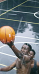 Men, basketball and net with point on court for outdoor match, game or competition together. Male people, athlete or sport players with opponent team, ball or hoop for score or goal on wet pitch