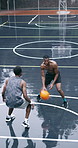 Men, basketball and net with goal on court for outdoor match, game or competition together. Male people, athlete or sport players with opponent team, ball or hoop for score or shoot on wet pitch